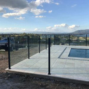 semi-frameless glass pool fence enclosing a pool overlooking a valley